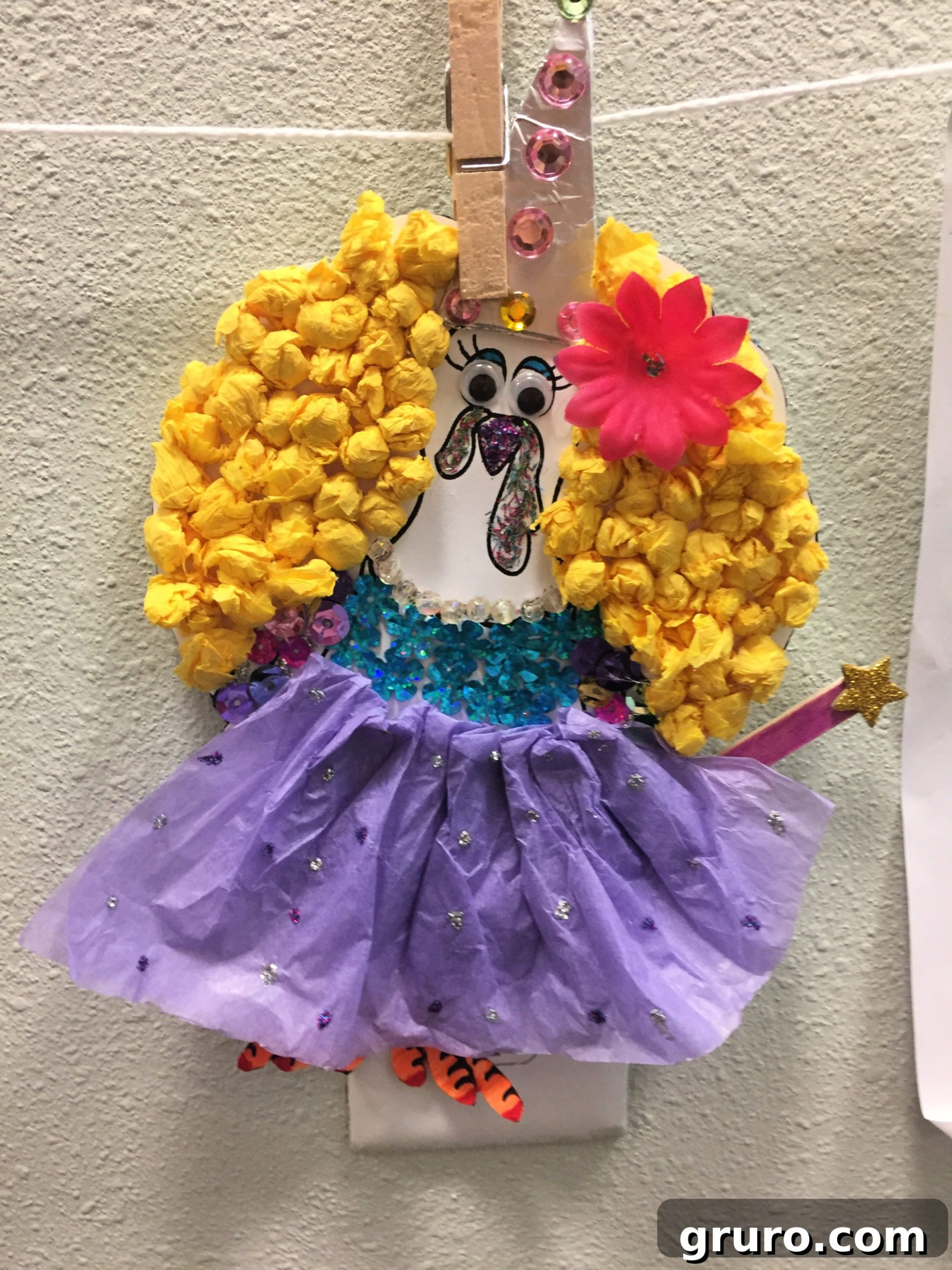 Cut Out Turkey In Disguise as a Fairy Godmother with little rolled tissue paper hair, pink flower, purple tissue paper skirt, and gems for a top.