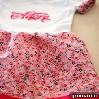 Onesie dress with floral skirt and pink trim