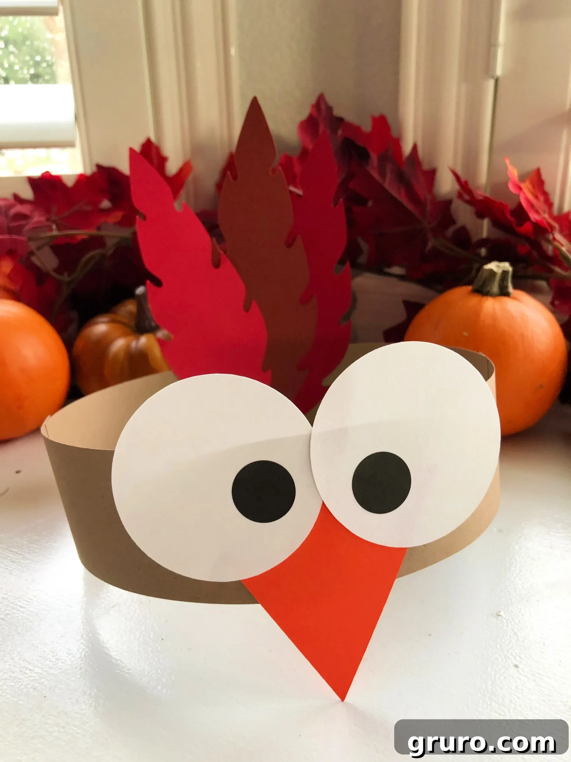 Turkey Paper Headbands for Kids with fall leaves and pumpkins in the background.