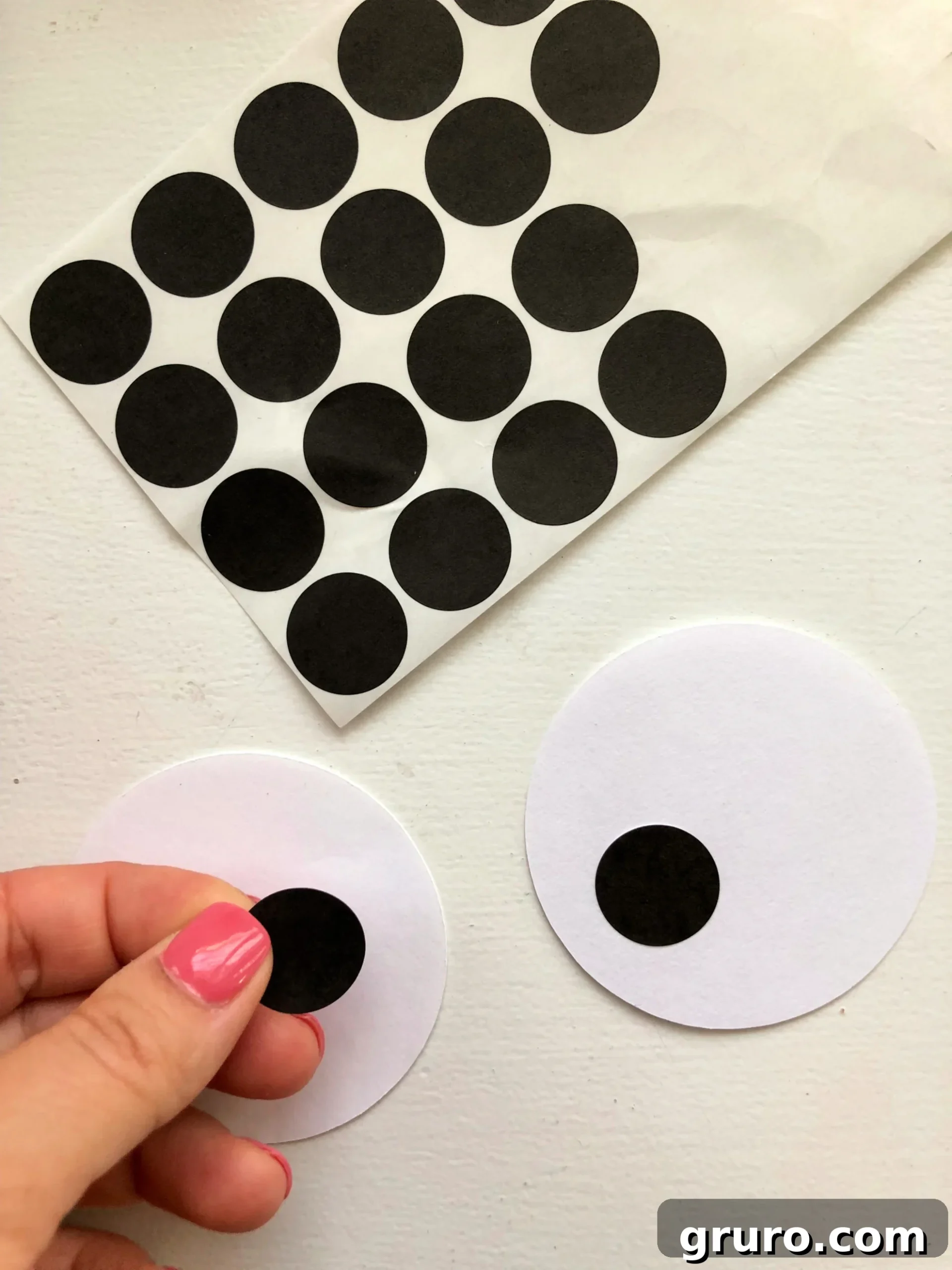 Black avery dot stickers pressed on to white circle paper cut outs.