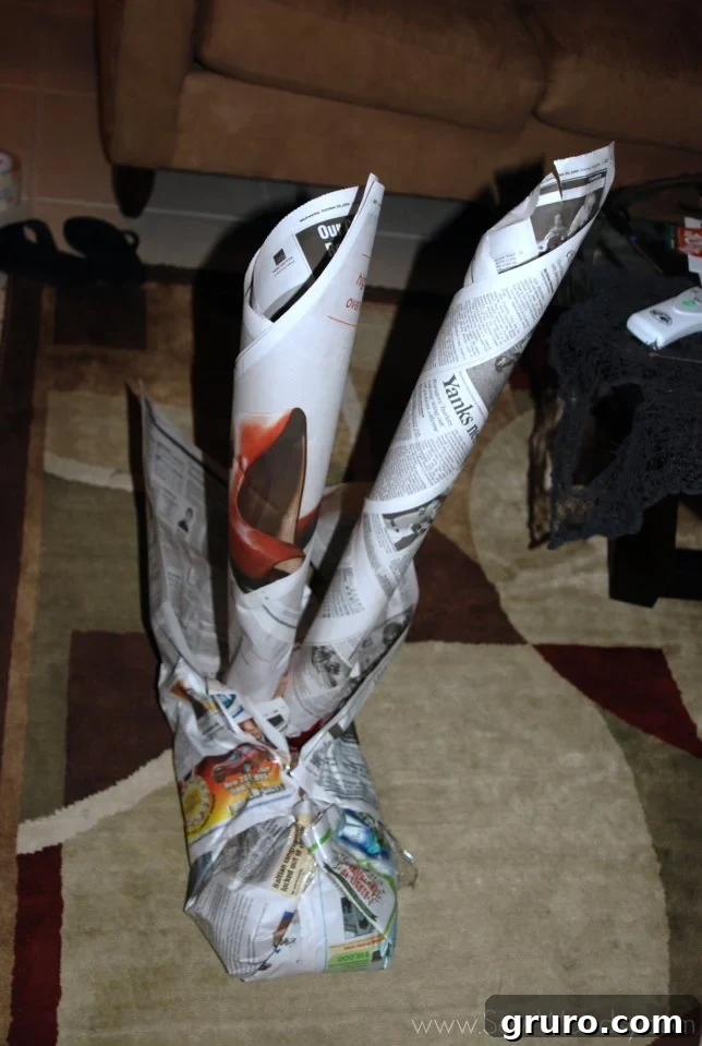 Forming the mummy's legs with rolled newspaper