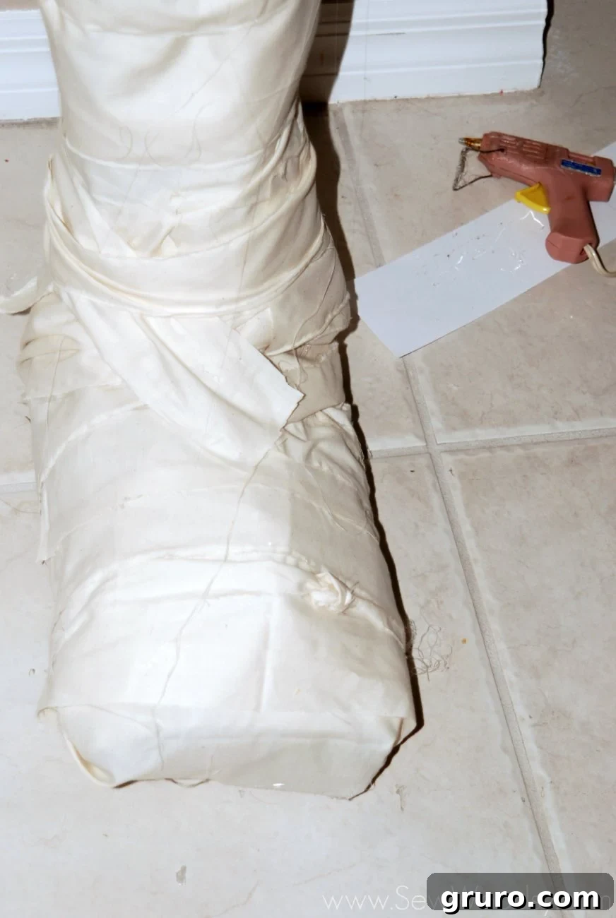 Close-up of muslin strips being applied to the mummy's feet