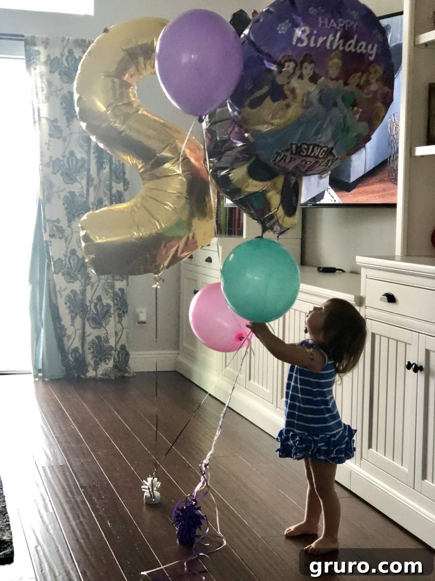Two-riffic Reagan! 2 Two-year-old girl celebrating her birthday with balloons