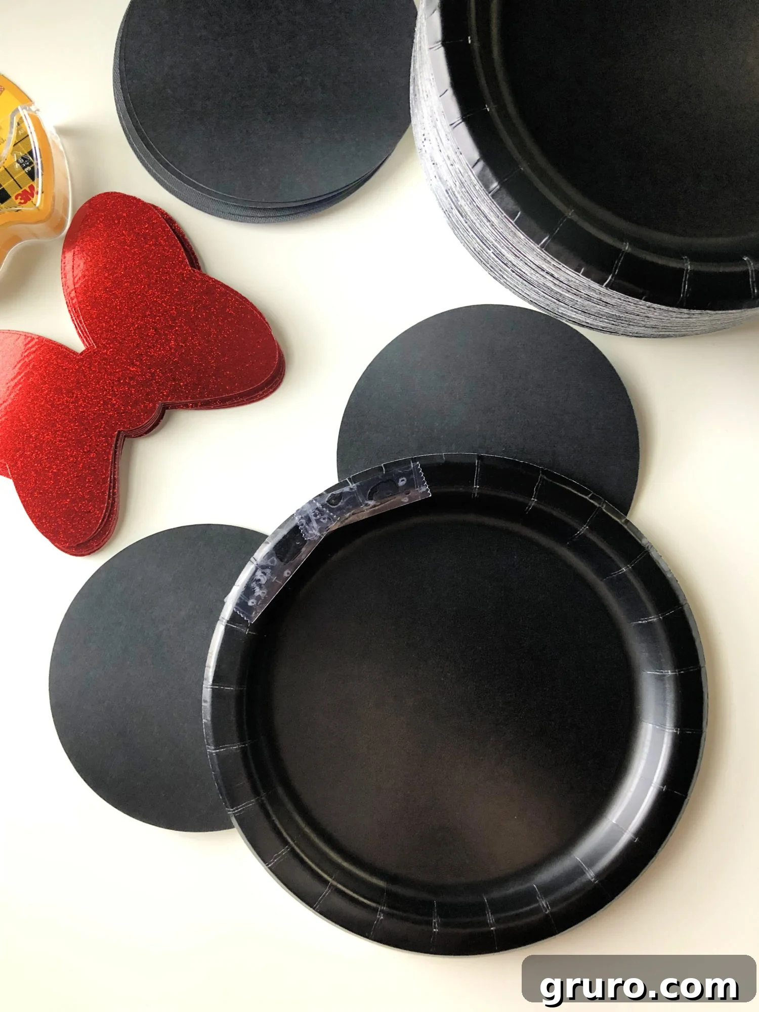 DIY Minnie Mouse Paper Plates Step 3 - Showing the plate with ears attached and placing tape for the bow.