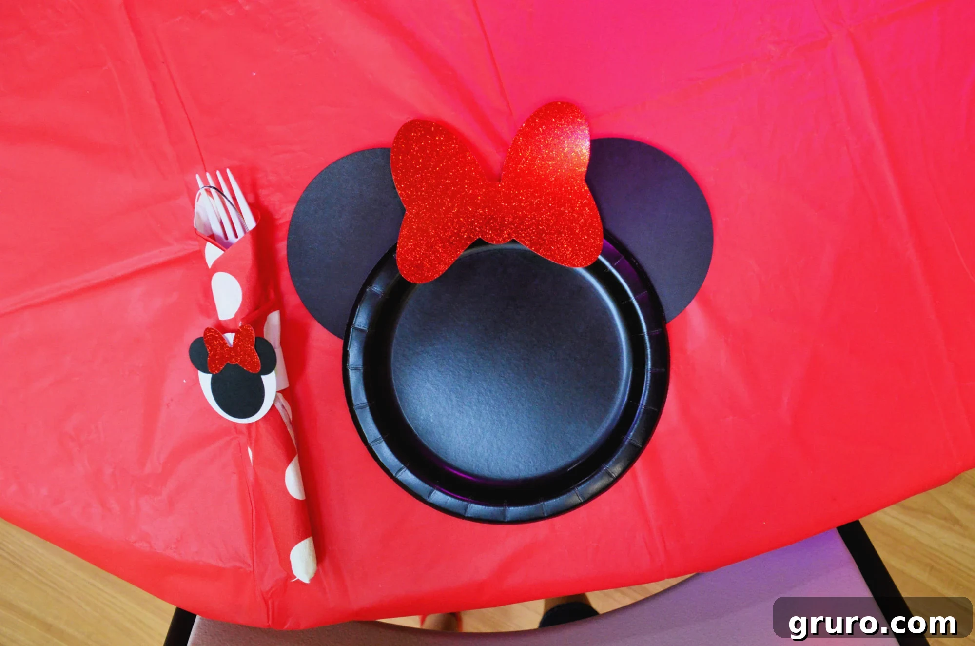 DIY Minnie Mouse Paper Plates displayed with Minnie Mouse plastic ware wraps for a complete table setting.