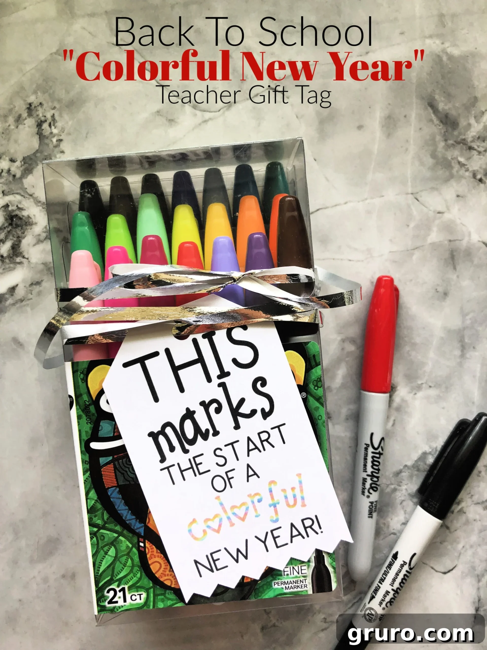 Box of Sharpie markers with a gift tag on it resting on marble countertop with text on image.