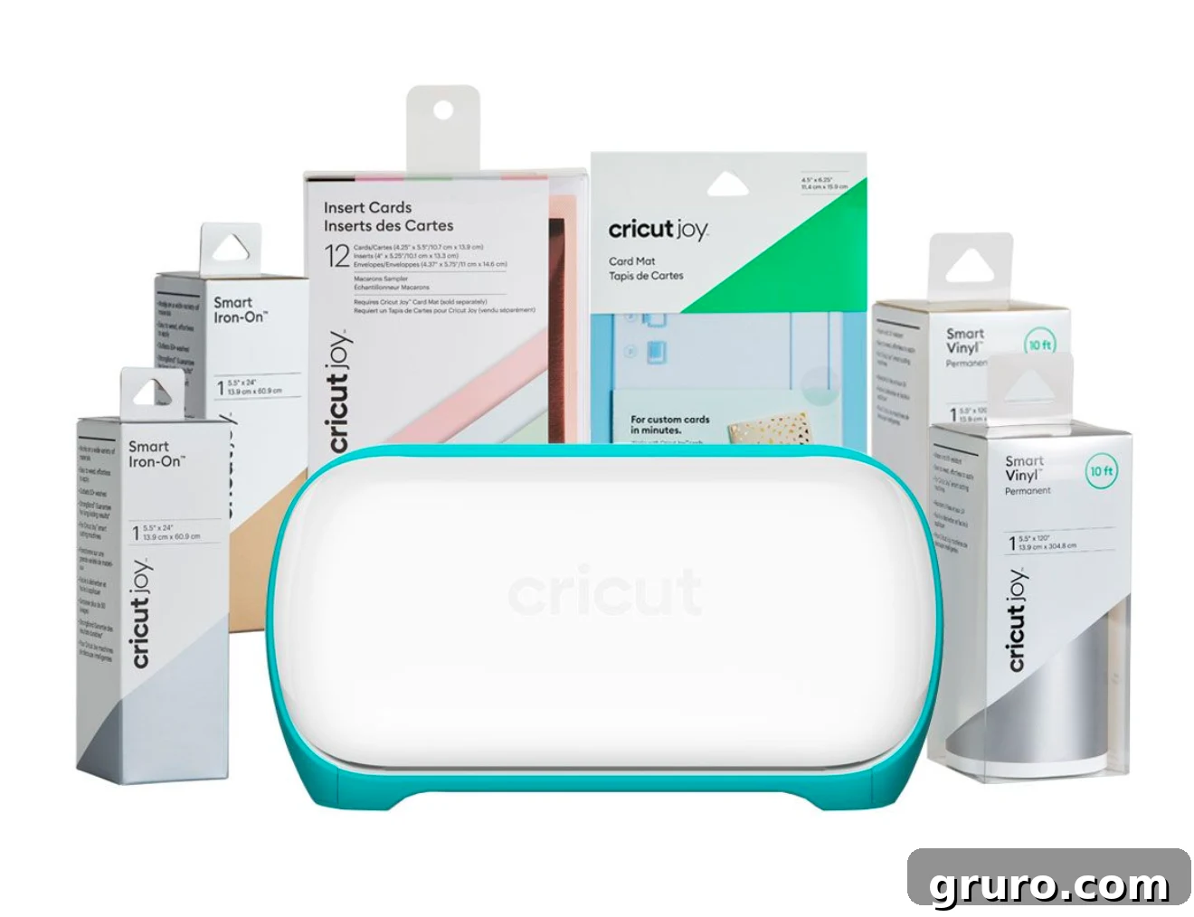 A compact blue Cricut Joy machine with its cutting mat, various rolls of Smart Vinyl, and card blanks arranged around it.