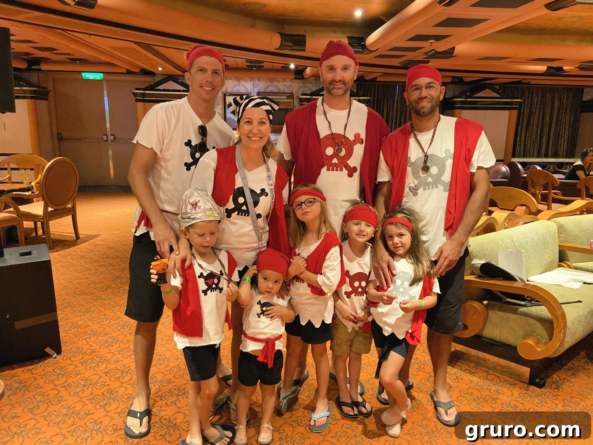 A large group of men, women, and children, all proudly wearing their DIY pirate shirts, showcasing a vibrant family or group costume theme.