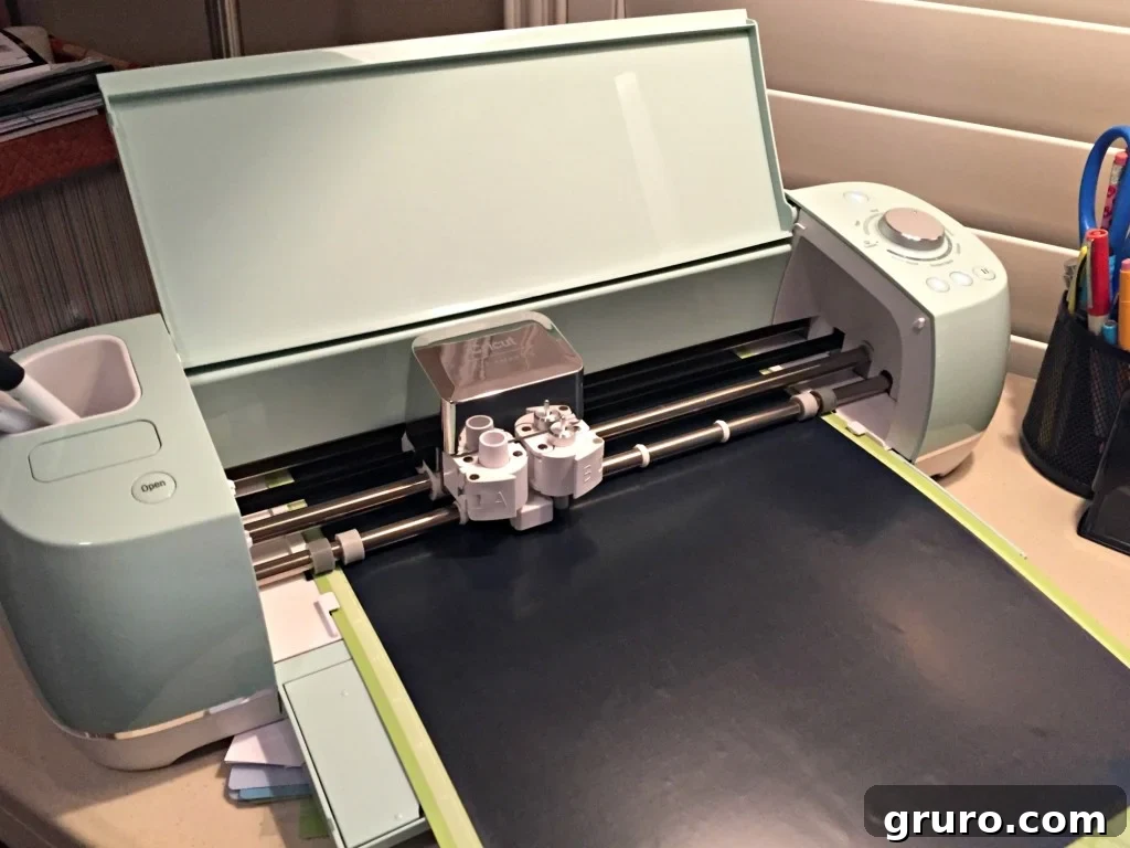 A green Cricut Explore Air 2 machine with black iron-on vinyl loaded and ready to cut.