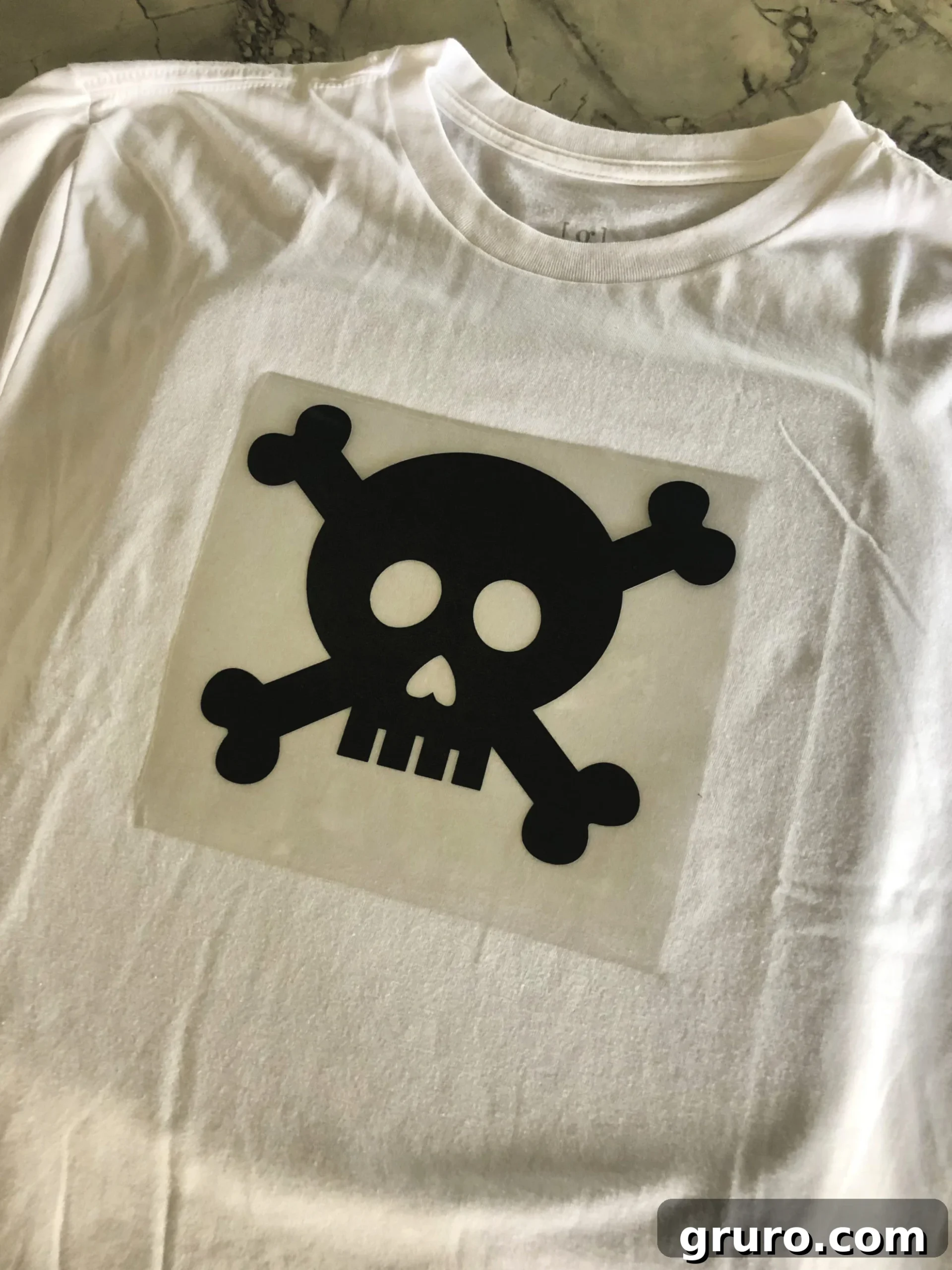 A white t-shirt featuring a striking black skull and crossbones design, ready for a pirate adventure.