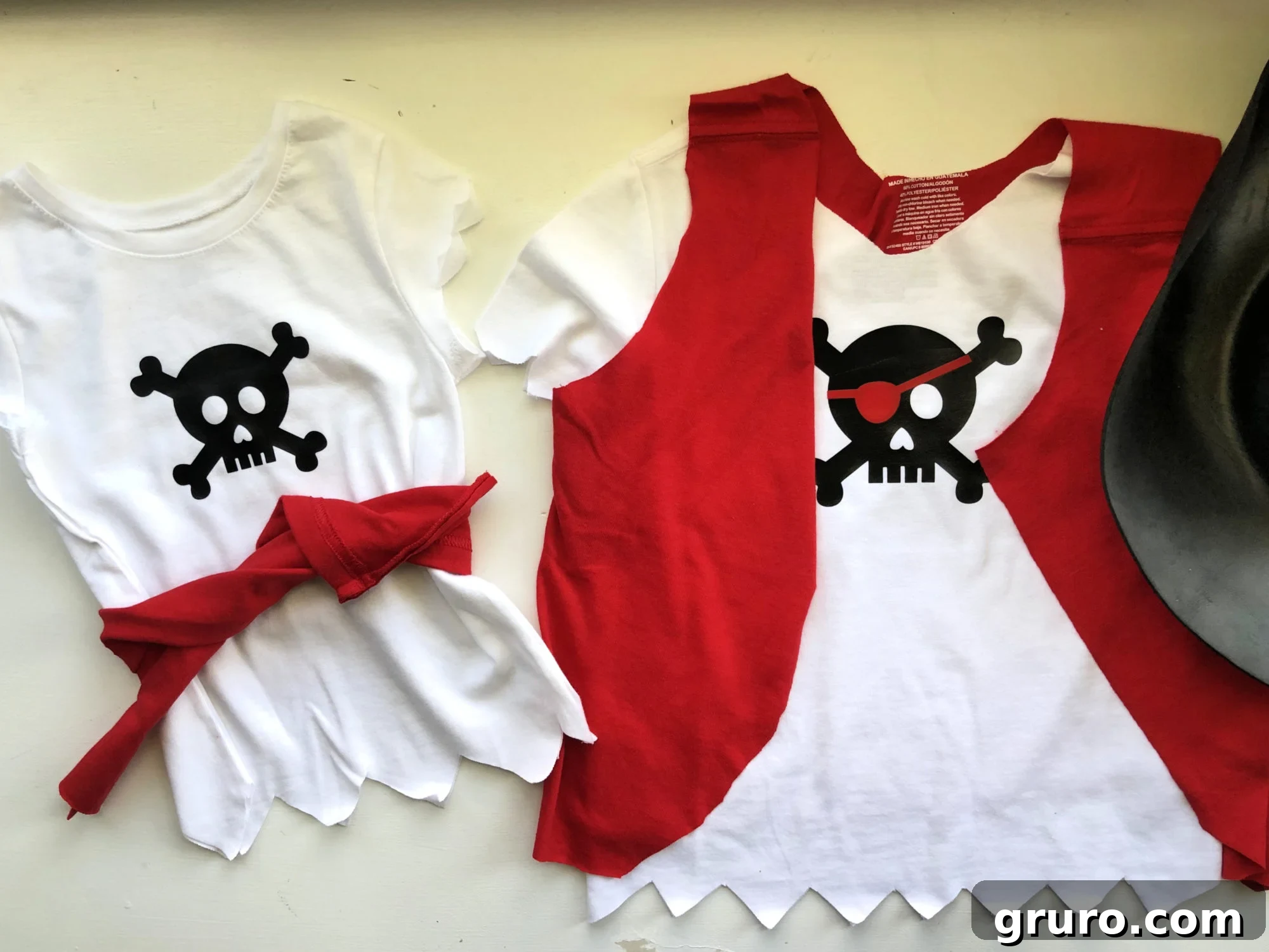 Two white pirate shirts, one with a red belt and another with a red vest, showcasing customized cuts for a pirate look.