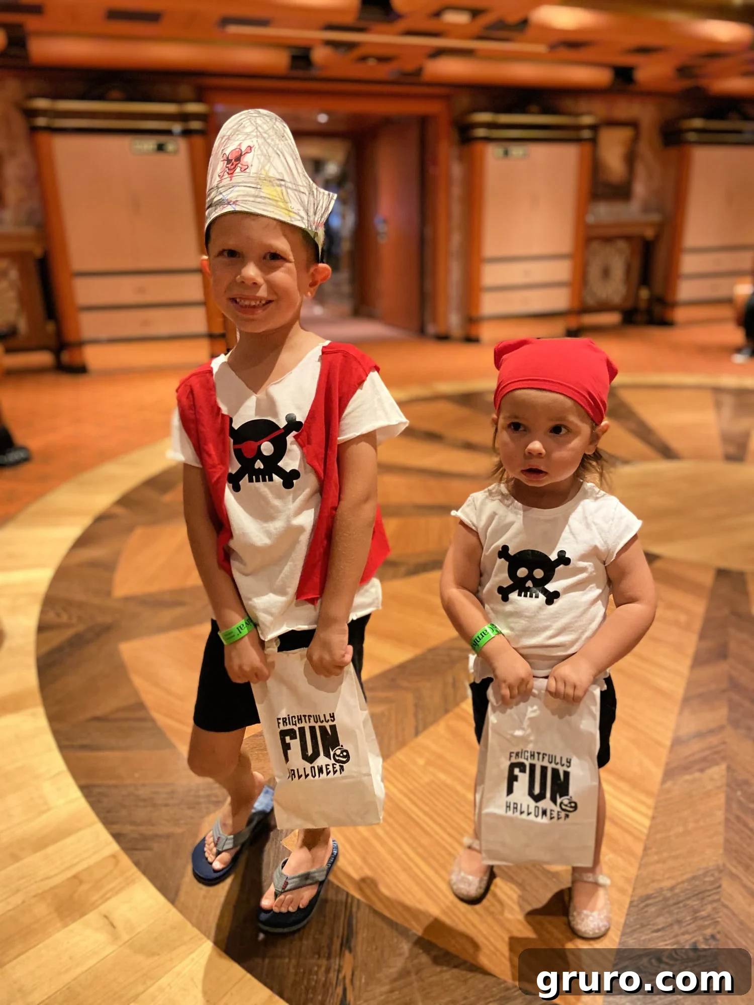 A brother and sister dressed in homemade pirate shirts, holding white paper bags after trick-or-treating, embodying the fun of family costumes.