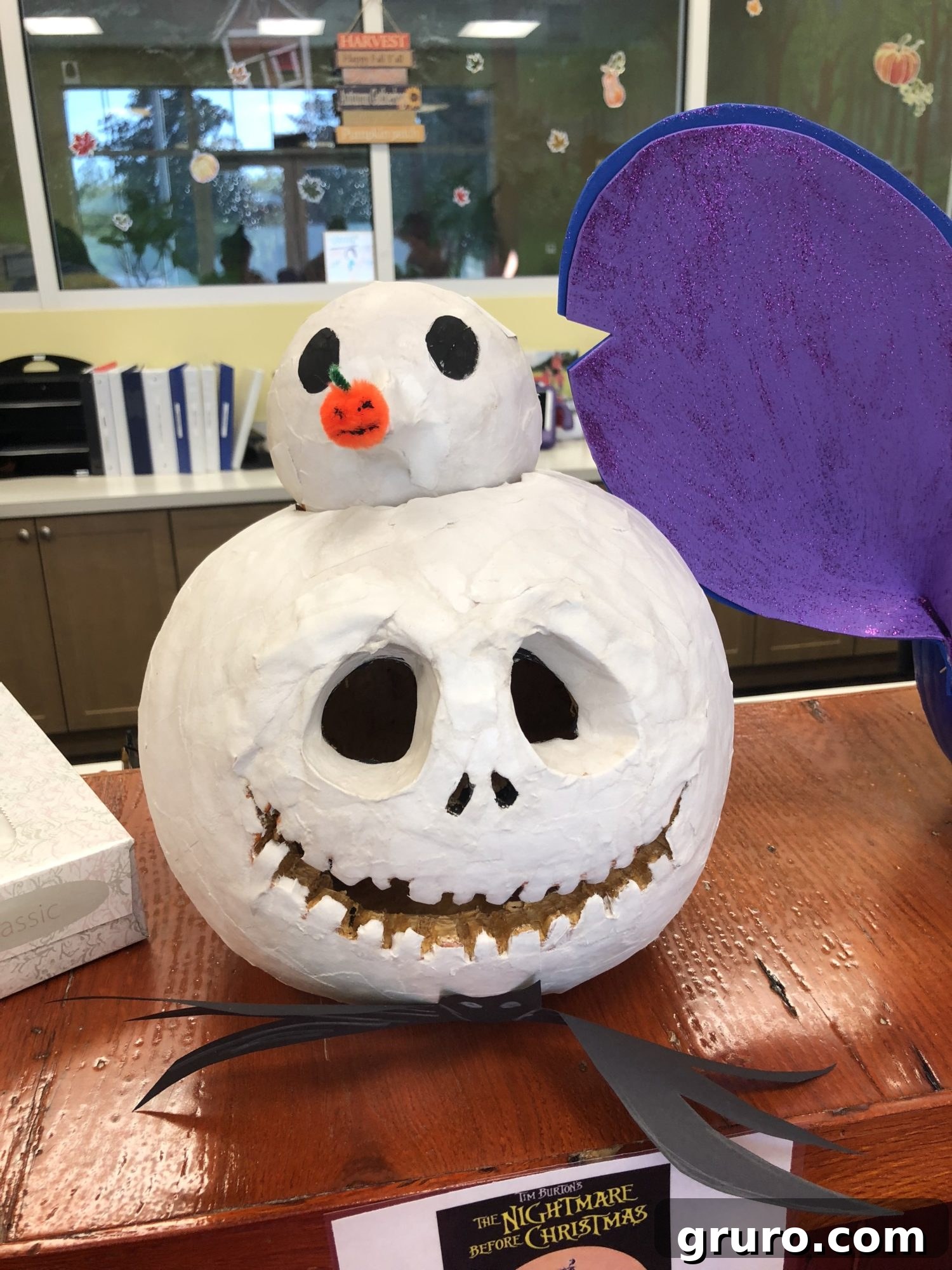 15 Creative No-Carve Pumpkin Decorations 12 A Jack Skellington carved pumpkin featuring his dog Zero on top, all painted white for a cohesive look.