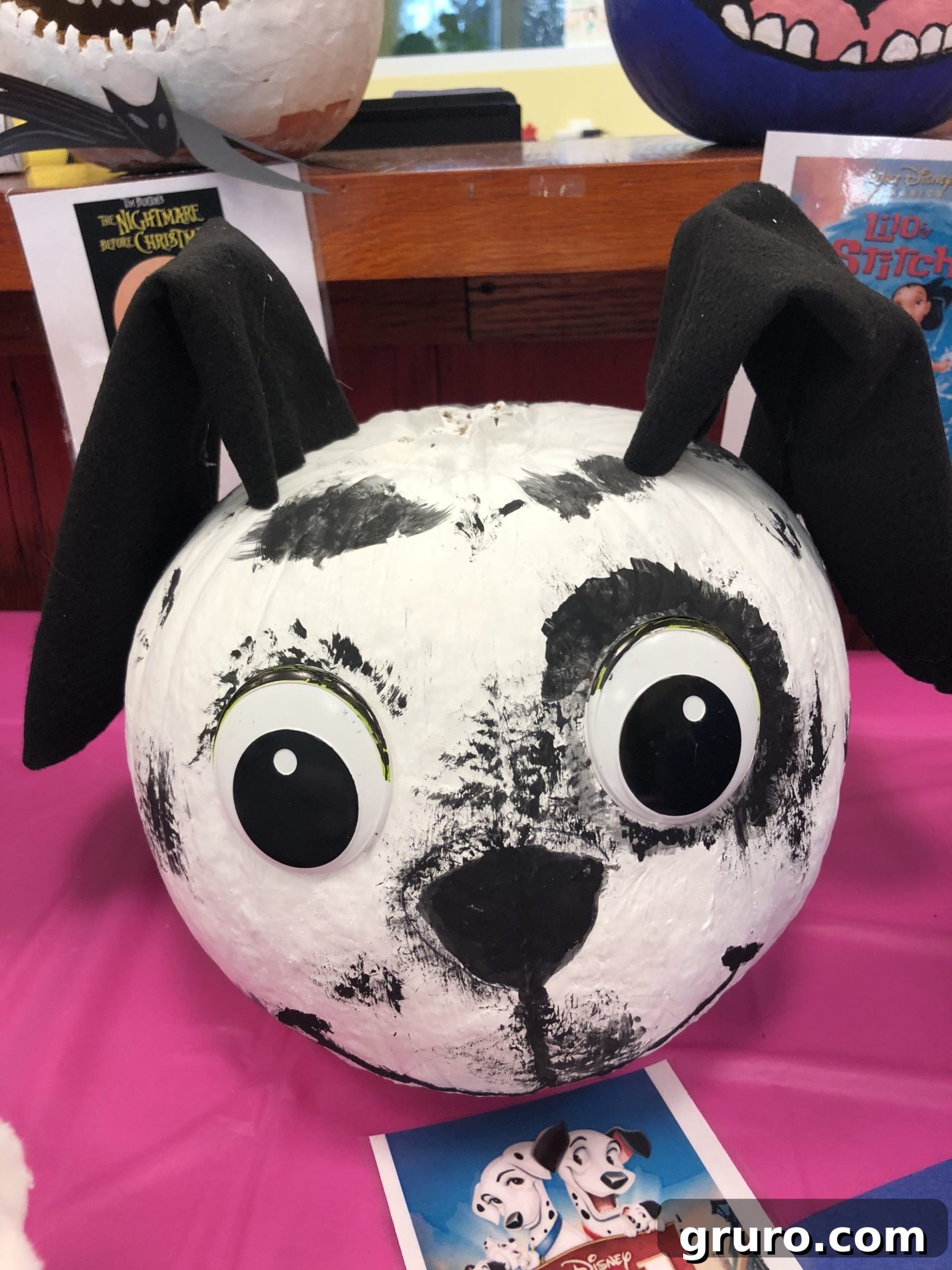 15 Creative No-Carve Pumpkin Decorations 14 A painted Dalmatian pumpkin adorned with black felt ears and three-dimensional eyes, creating an adorable dog-themed decoration.