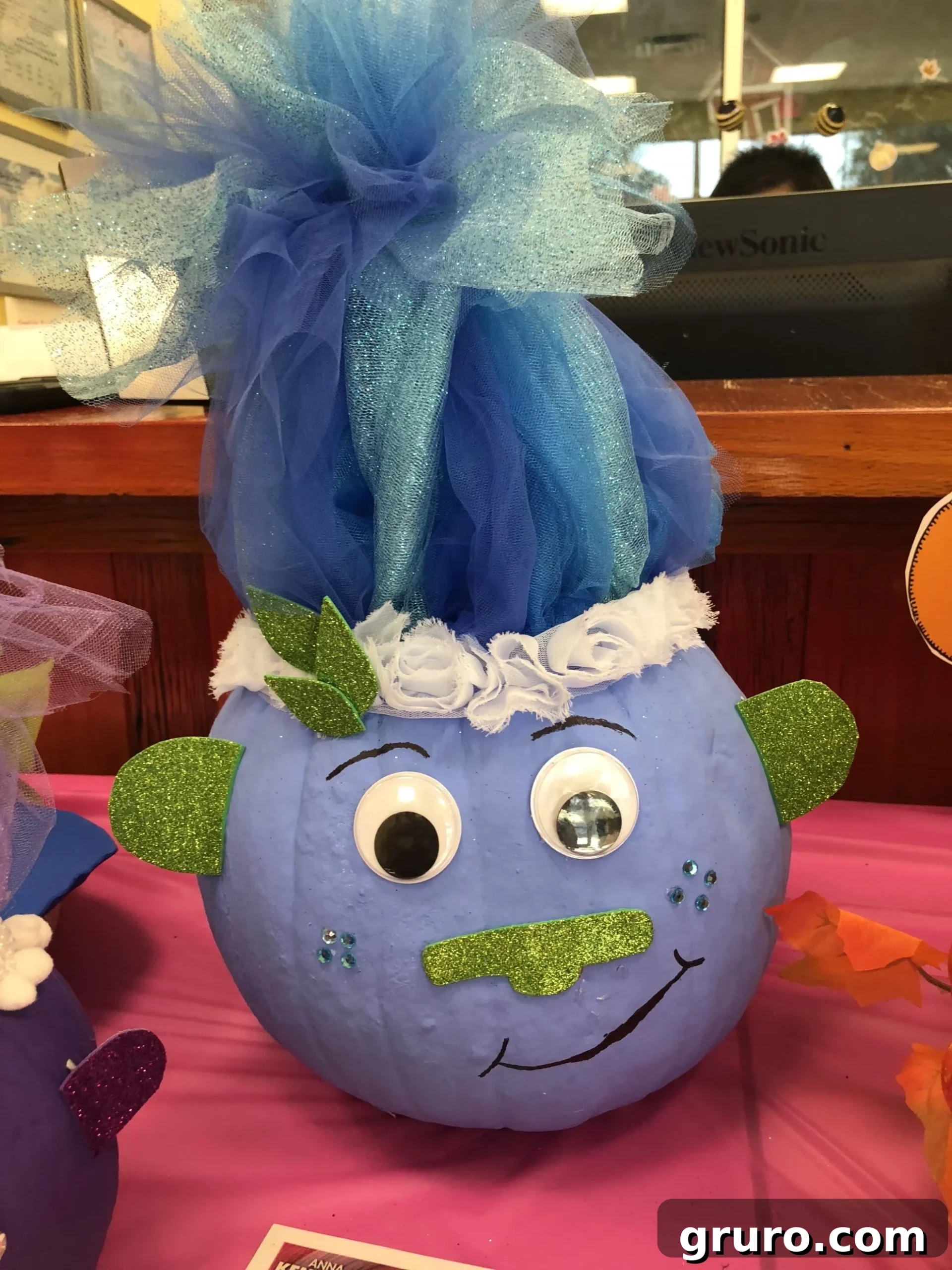 15 Creative No-Carve Pumpkin Decorations 15 A vibrant blue Troll pumpkin featuring green glitter foam and a playful blue tulle hairdo.