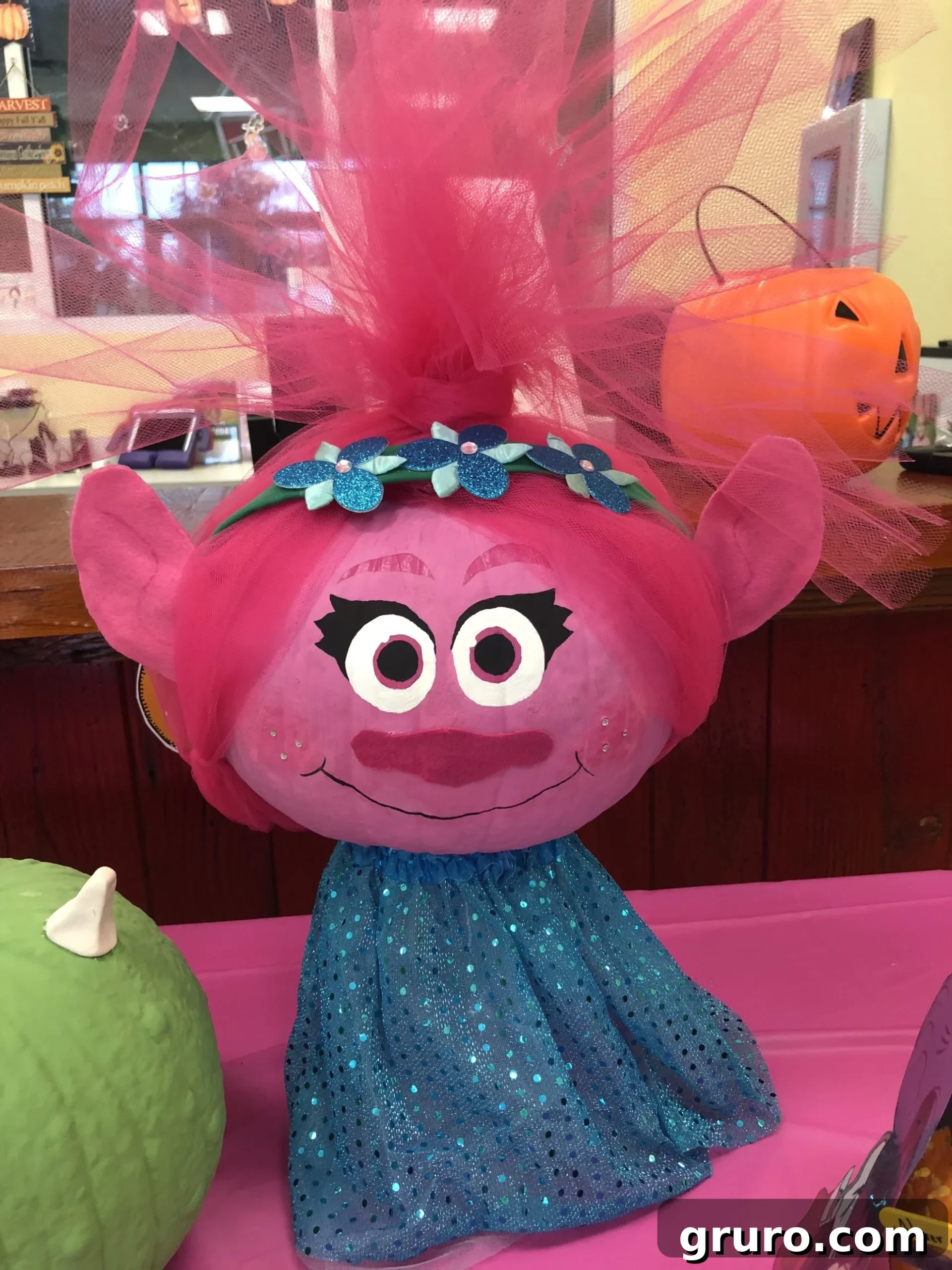 15 Creative No-Carve Pumpkin Decorations 17 A pink painted Princess Poppy pumpkin featuring bright pink tulle for her iconic hair.