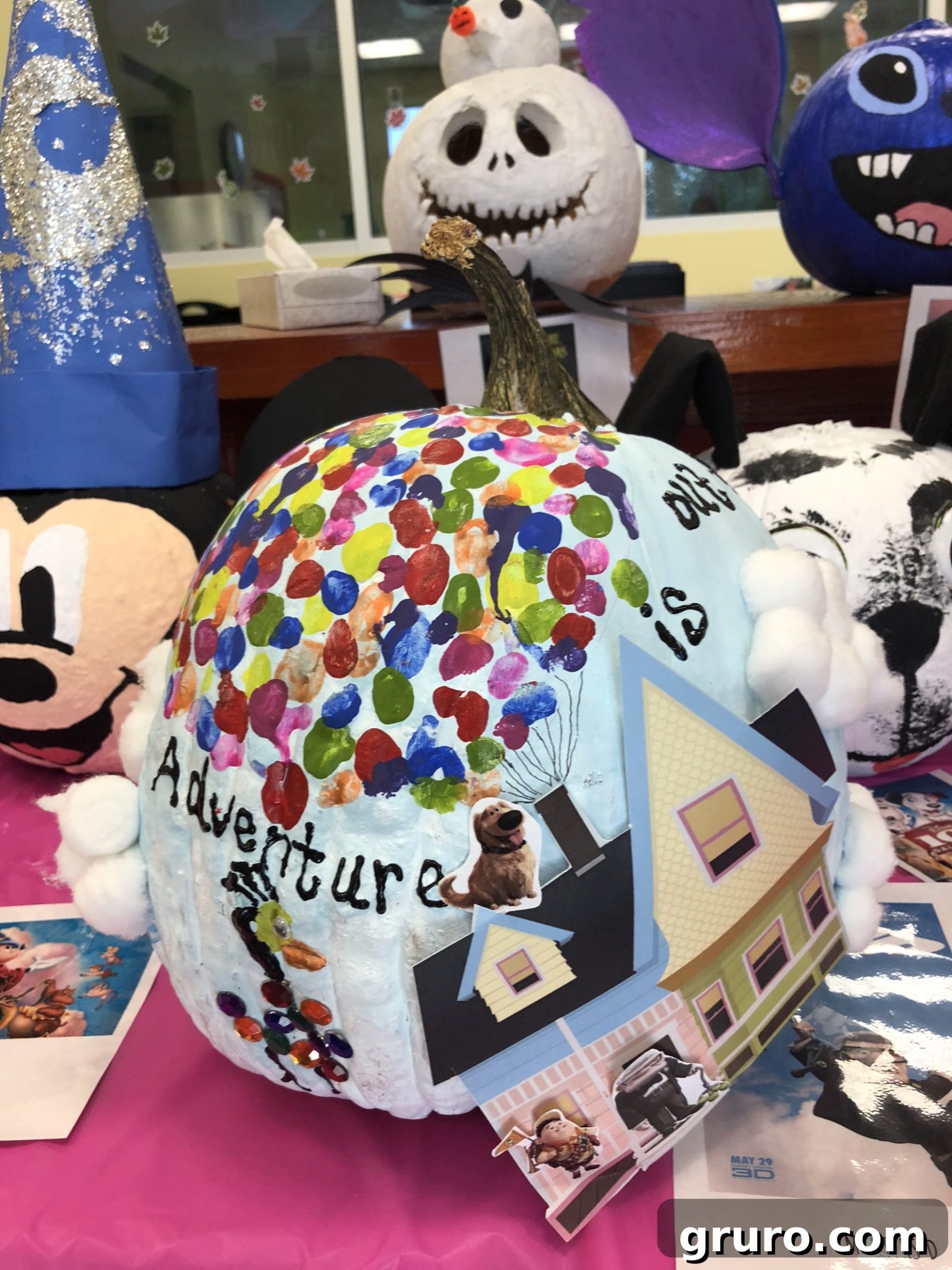 15 Creative No-Carve Pumpkin Decorations 3 Disney's UP! themed painted pumpkin featuring a printed house and colorful hand-painted balloons, with cotton balls for clouds.