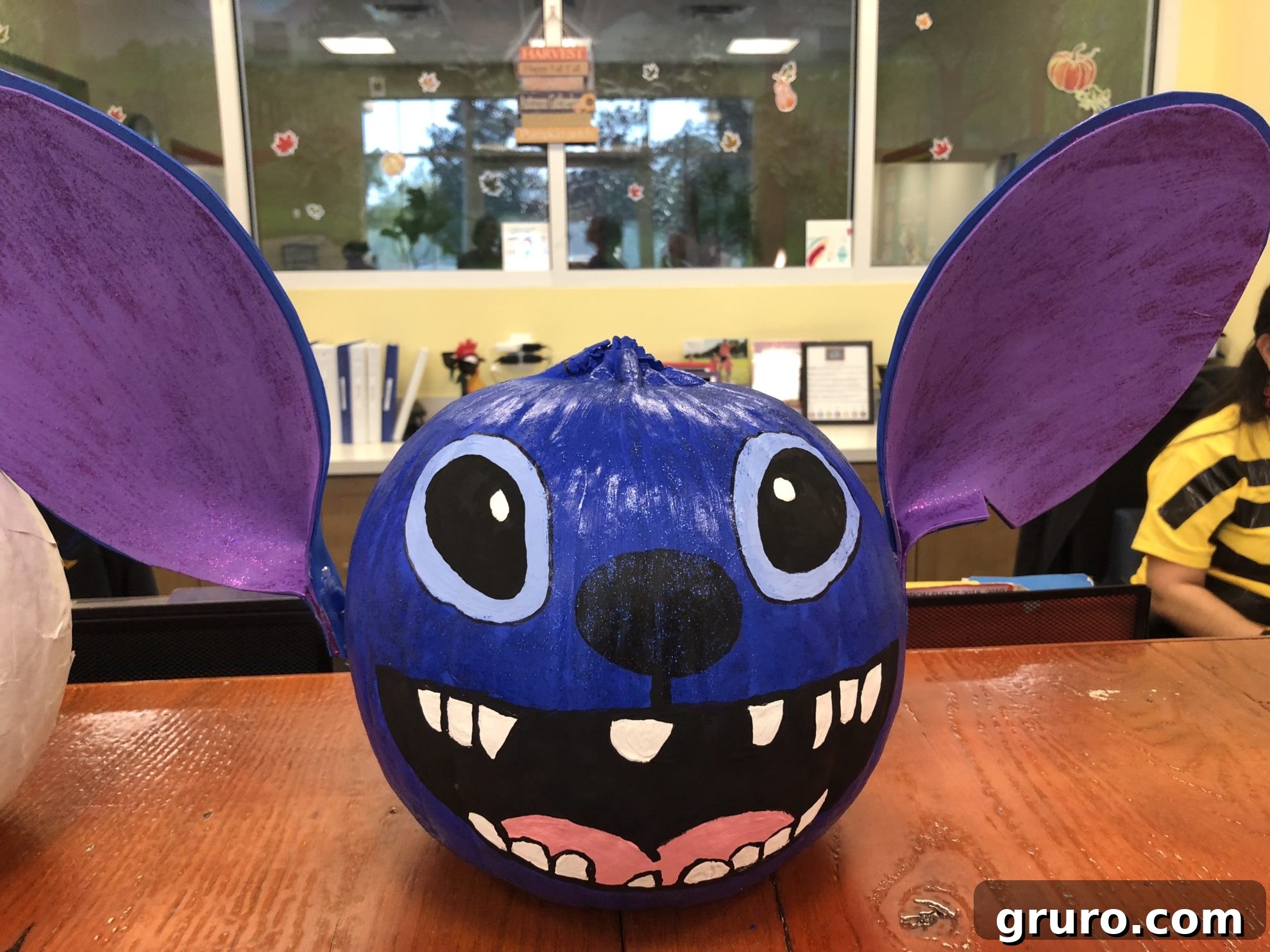 15 Creative No-Carve Pumpkin Decorations 4 A vibrant blue painted Stitch pumpkin, featuring large craft foam ears characteristic of the Disney character.