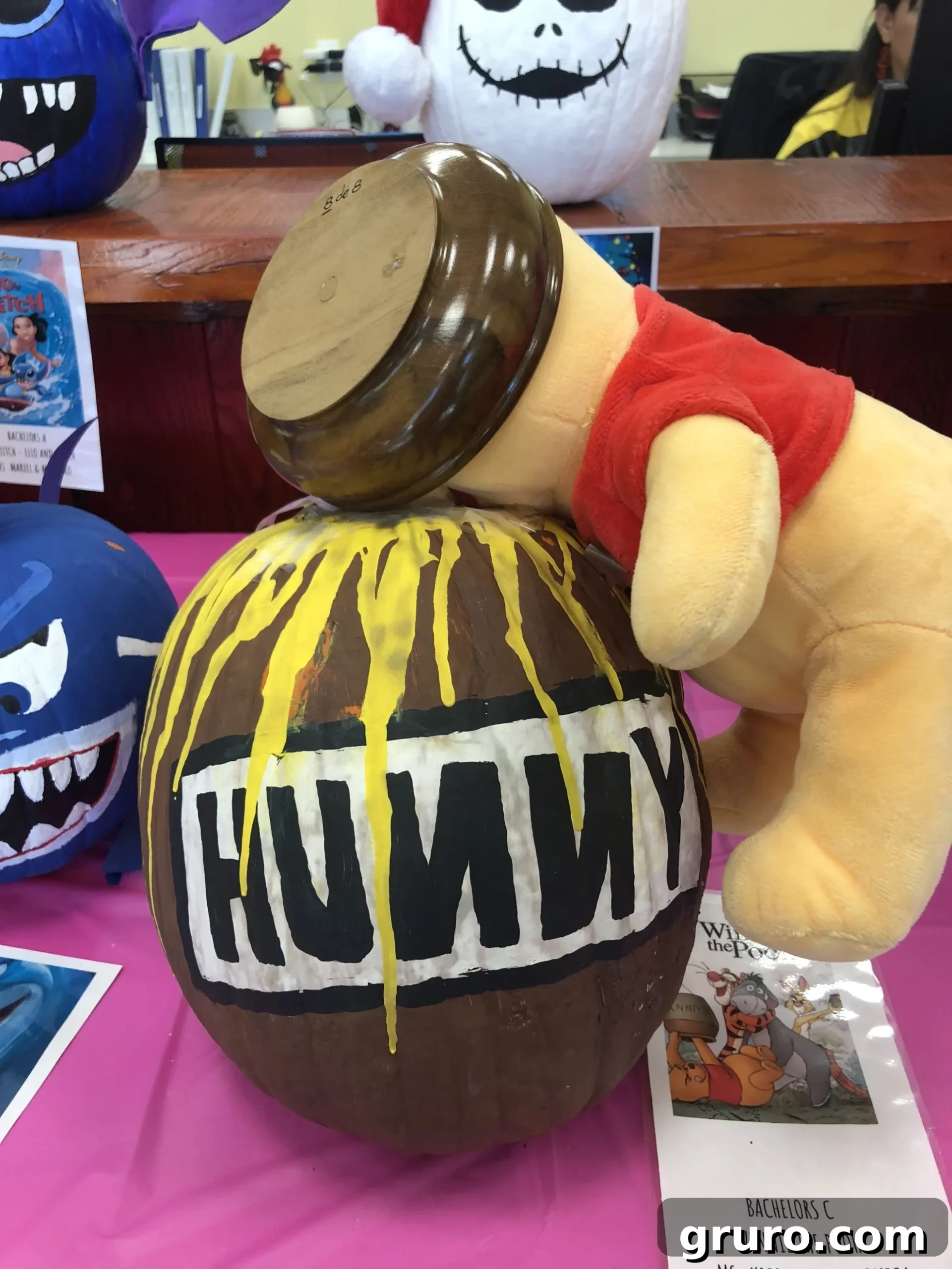 15 Creative No-Carve Pumpkin Decorations 10 A delightful Winnie the Pooh stuffed animal seemingly stuck head-first in a painted brown honey pot pumpkin.