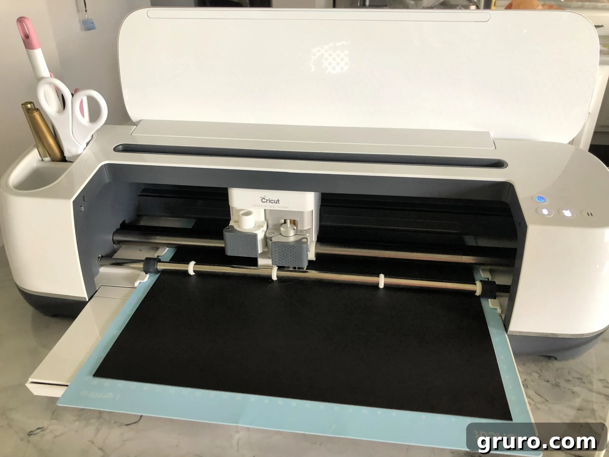 Cricut Maker cutting black Kraft board for paper spiders.