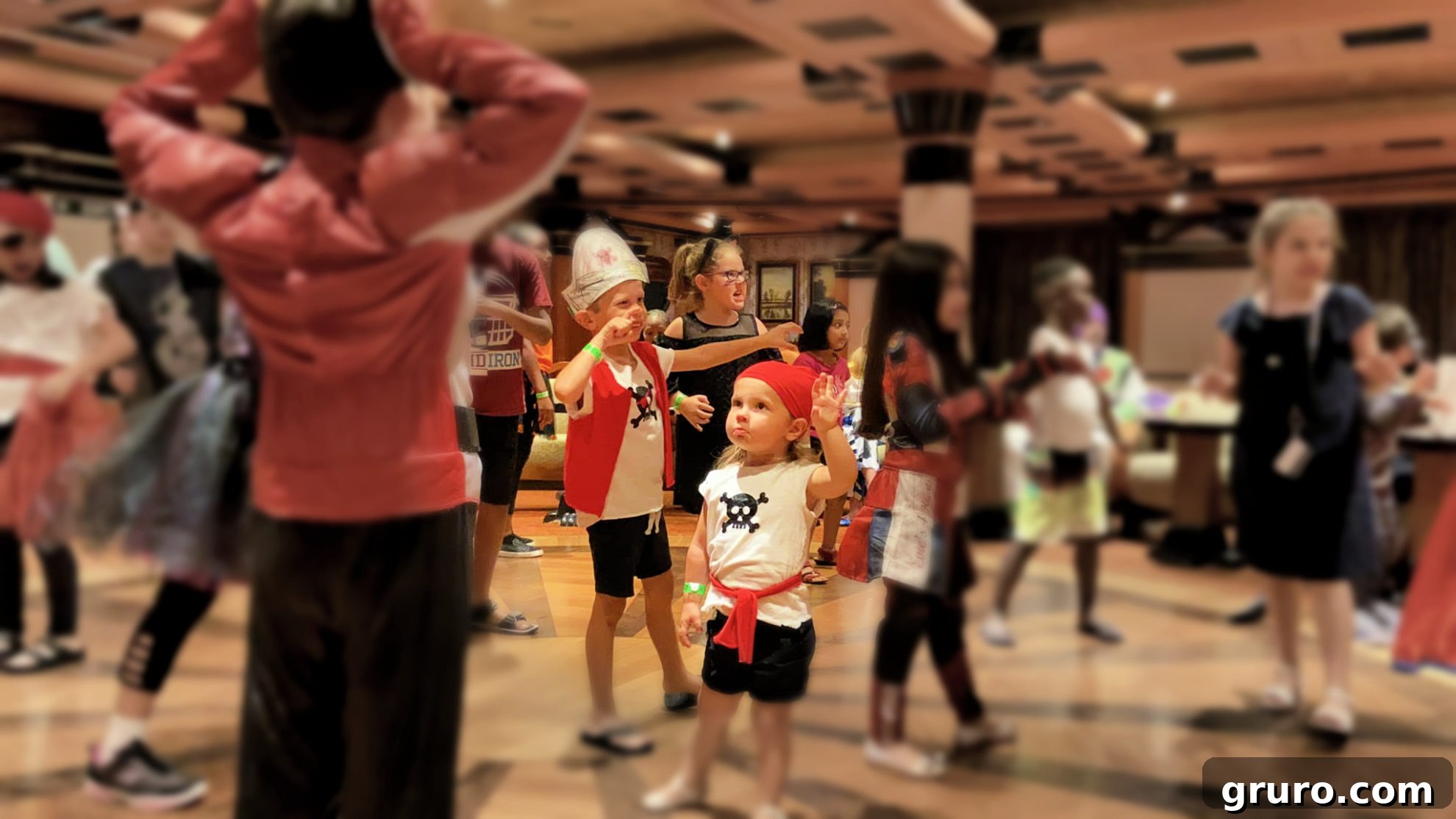 Little girl dressed as a pirate dancing enthusiastically at a Halloween party on a Carnival Cruise.