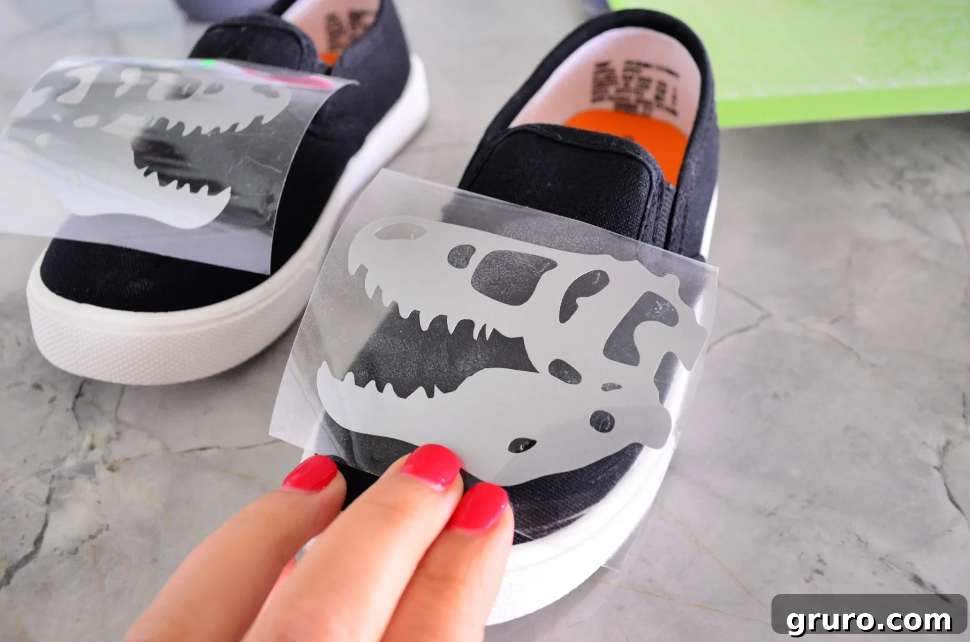 Aligning Dinosaur Iron-On Vinyl design on canvas shoes