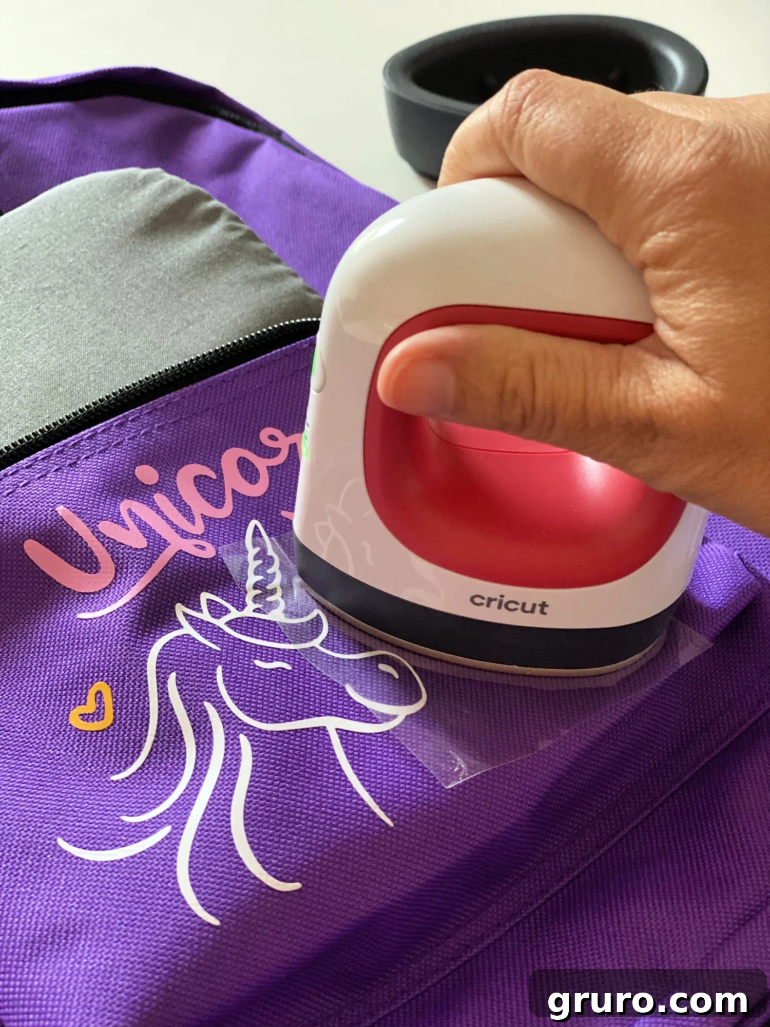 Using the Cricut EasyPress Mini to press iron-on vinyl onto a backpack