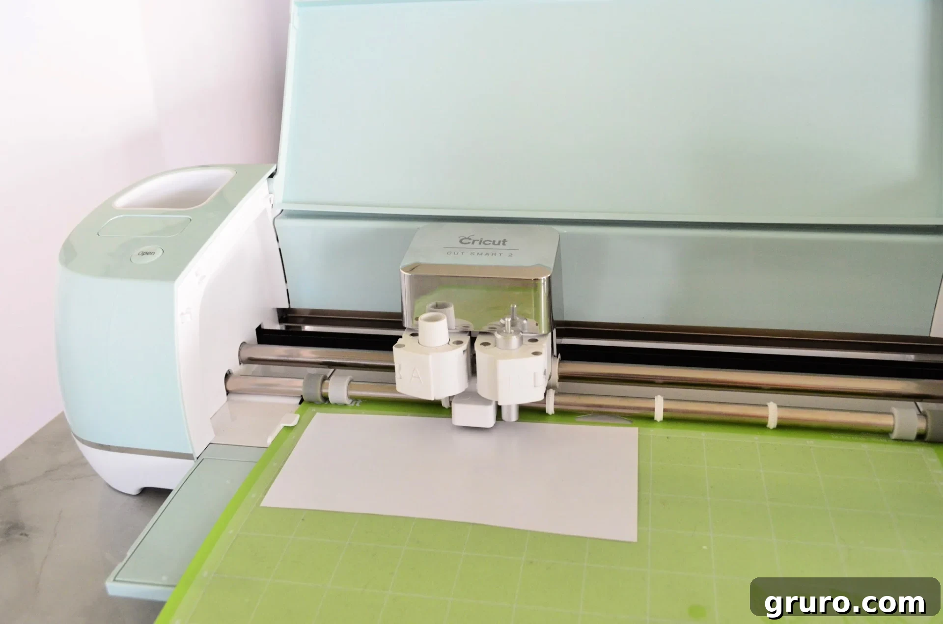 Cricut Explore Air 2 machine with the Smart Dial set to 'Iron-On' for cutting white Iron-On Vinyl.