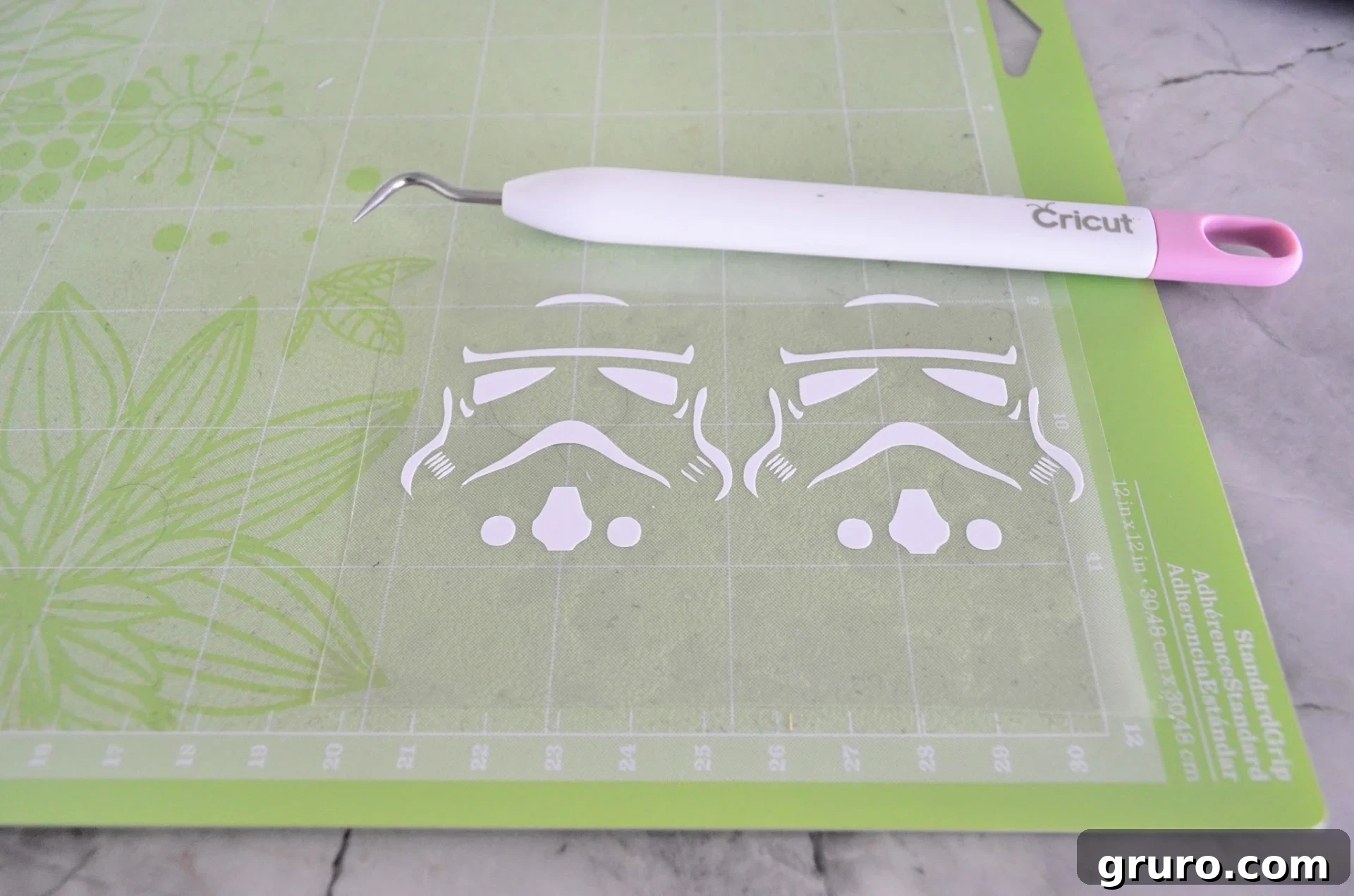 Weeded Stormtrooper helmet design on a green StandardGrip Cricut Mat, with excess vinyl removed, showing the clean design ready for transfer.