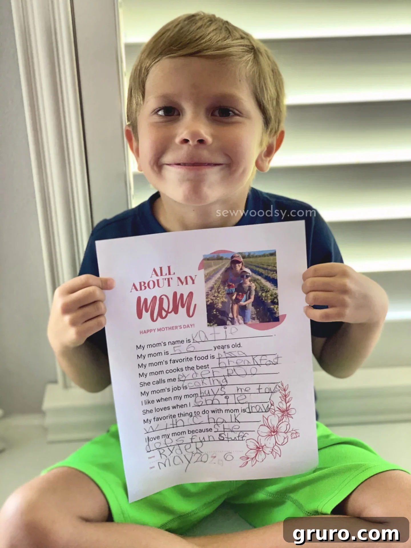 A sweet kindergarten-aged boy diligently filling out his Mother's Day Questionnaire Printable, focused on creating a special gift.