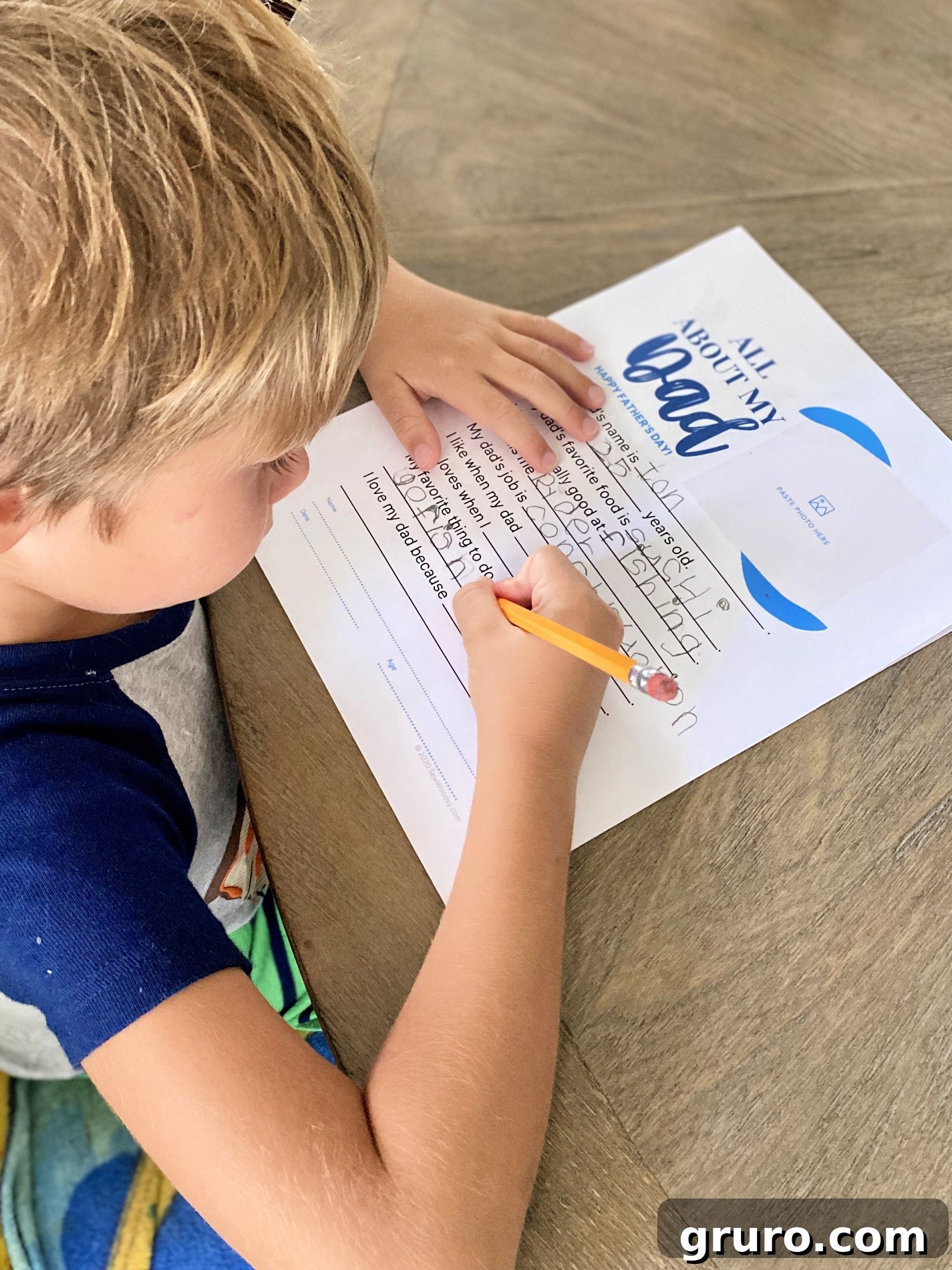 Child thoughtfully filling out the Father's Day questionnaire worksheet.