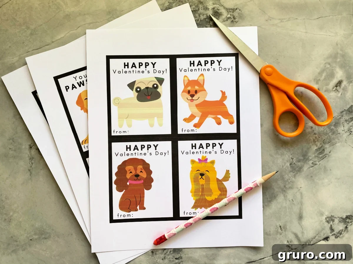 A creative flat lay showing three sheets of paper with dog valentines printed, accompanied by a pencil and scissors, ready for crafting.
