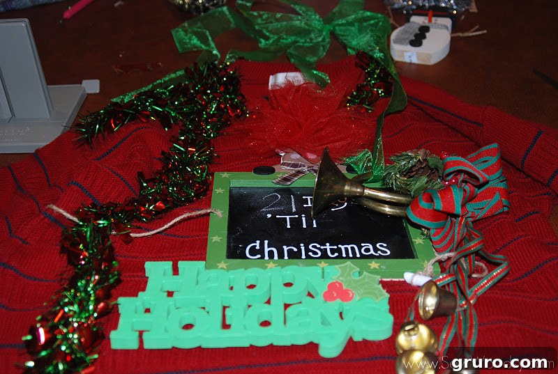 Assortment of Christmas decorations laid out, ready for sweater embellishment.