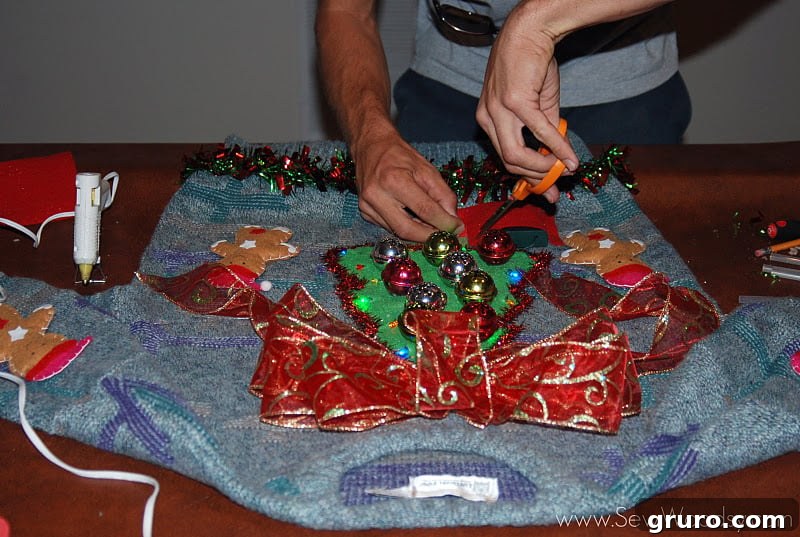 Mr. Woodsy applying hot glue to his tacky Christmas sweater.