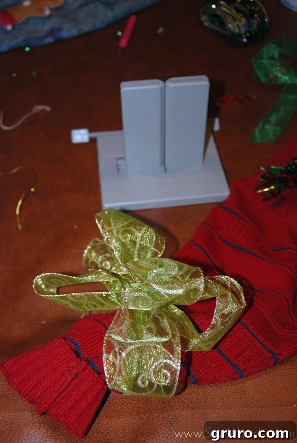 Mr. Woodsy attaching battery-operated lights to a felt Christmas tree on his sweater.