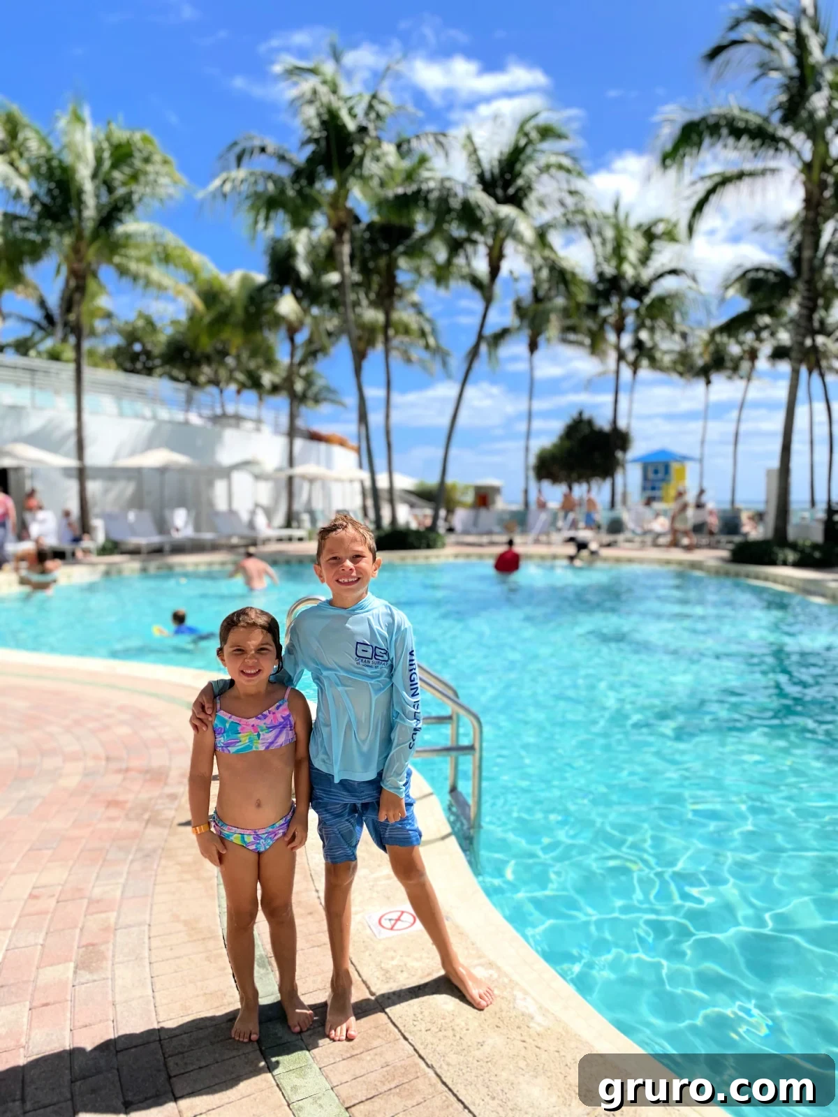 Two children standing next to a pool at The Diplomat Beach Resort, highlighting its kid-friendly environment.