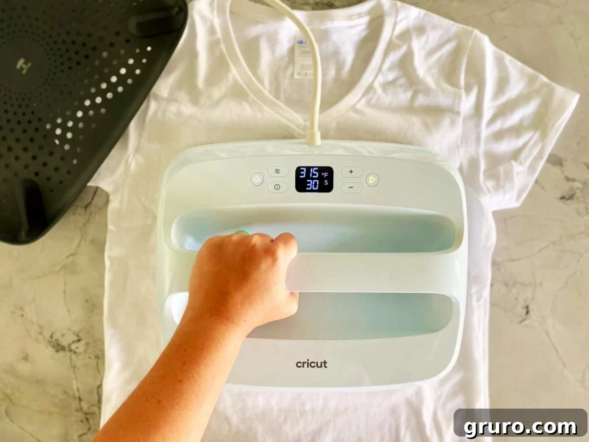 Handing pressing down a light blue EasyPress on a white shirt.