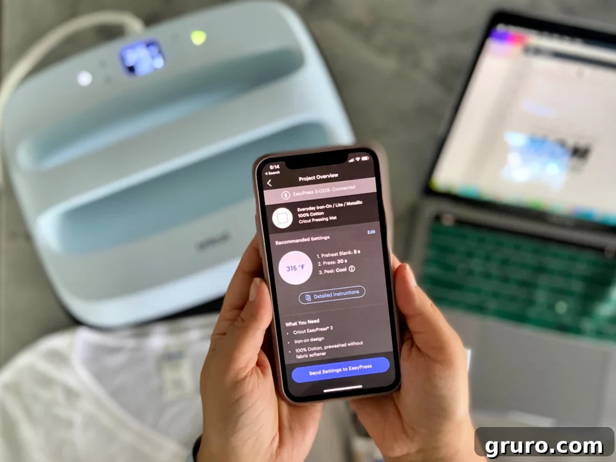 Female hand holding smart phone with a heat app open with a computer and EasyPress in the background.