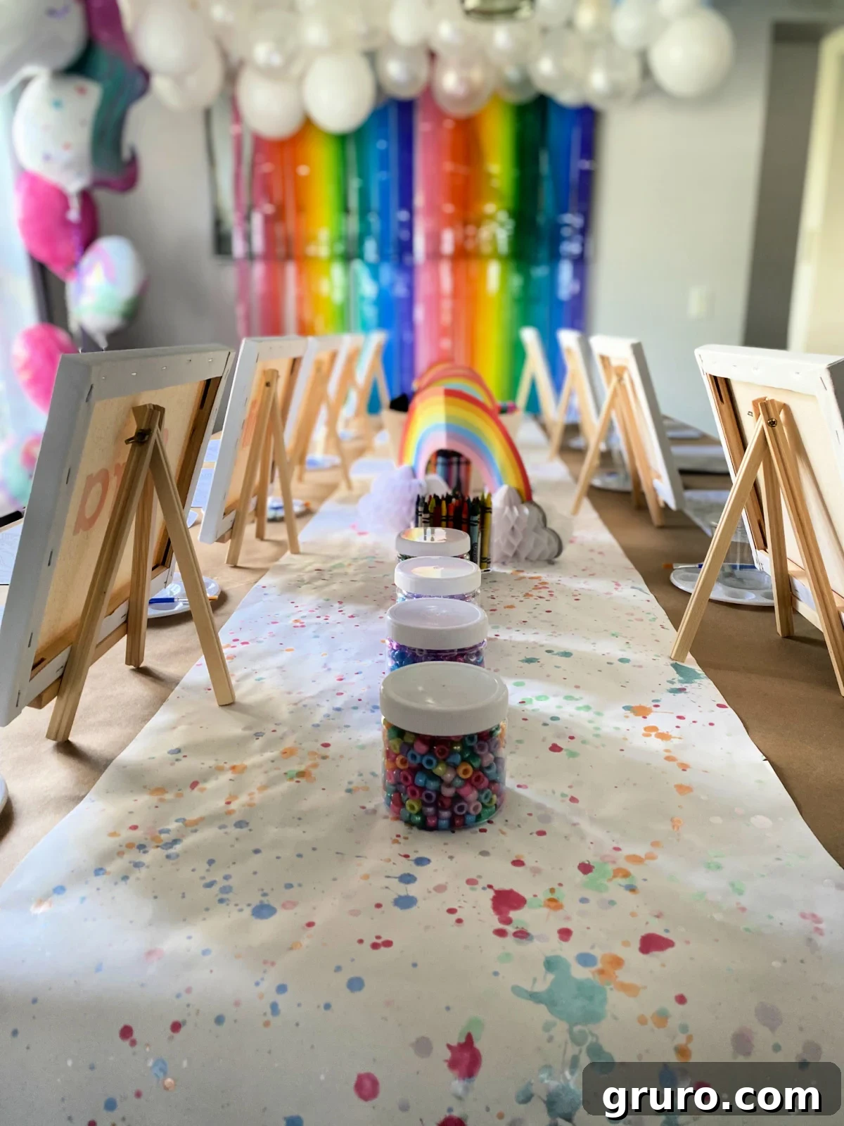 Four bead jars in the middle with easels and canvas on them.