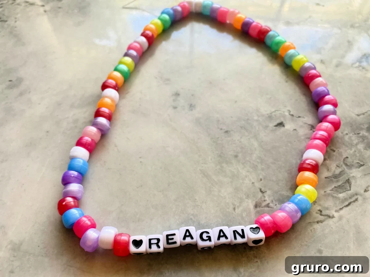 Beaded multi-color necklace with two hearts and the name "reagan".
