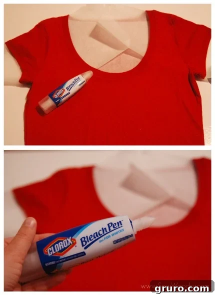 A person carefully placing a sheet of parchment paper inside a dark, flat-laid t-shirt to protect the back layer from bleach penetration during a DIY customization project.