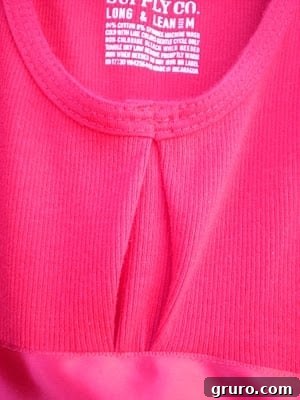 A close-up view of the hand-stitched adjustment made on the front bodice of the toddler dress to improve fit.