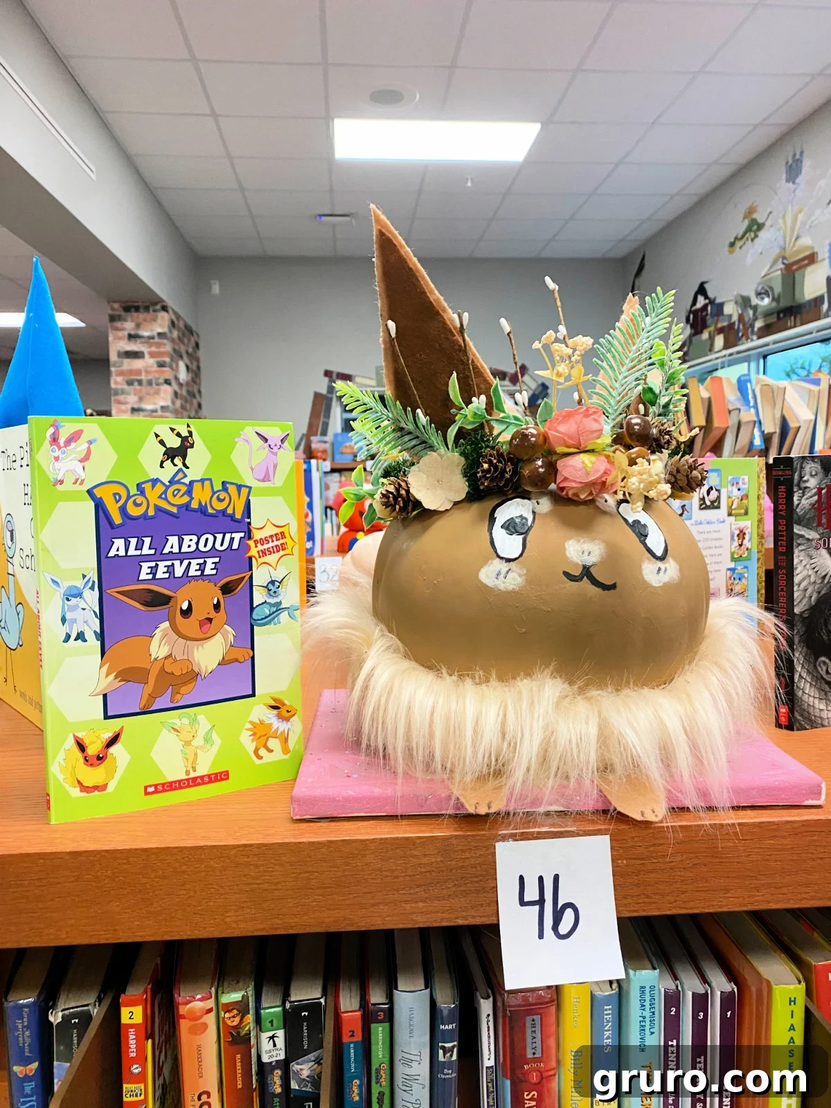 Brown Eevee pumpkin next to a Pokemon book.