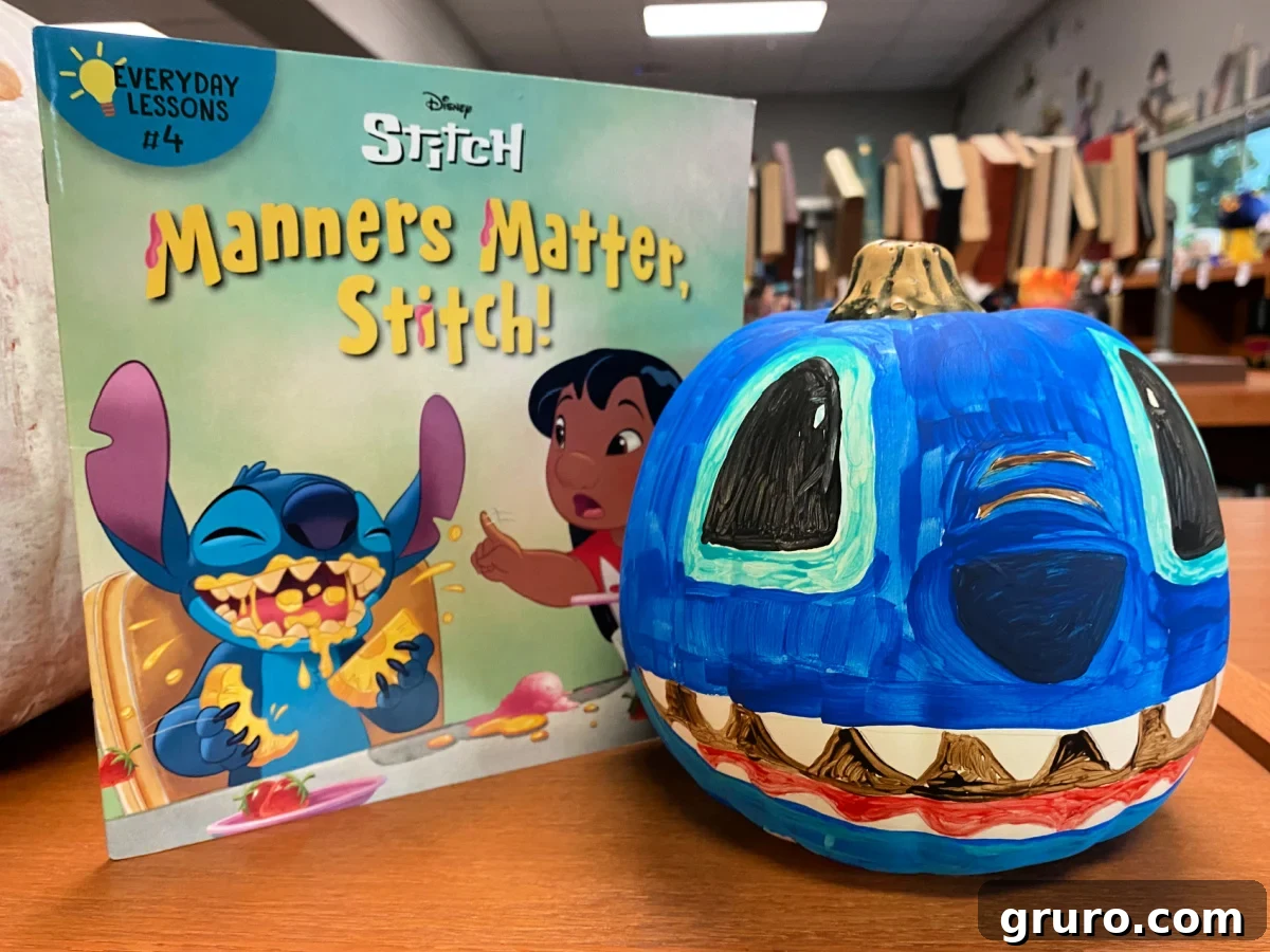 Blue Disney stitch pumpkin next to a Stitch book.