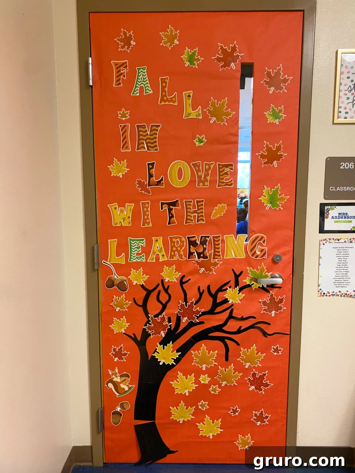 Orange classroom door with tree and fall leaves.