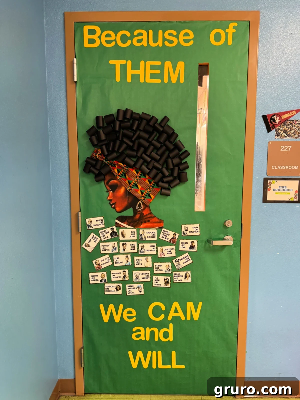Green paper on door with african american woman with words "because of them we can and will"