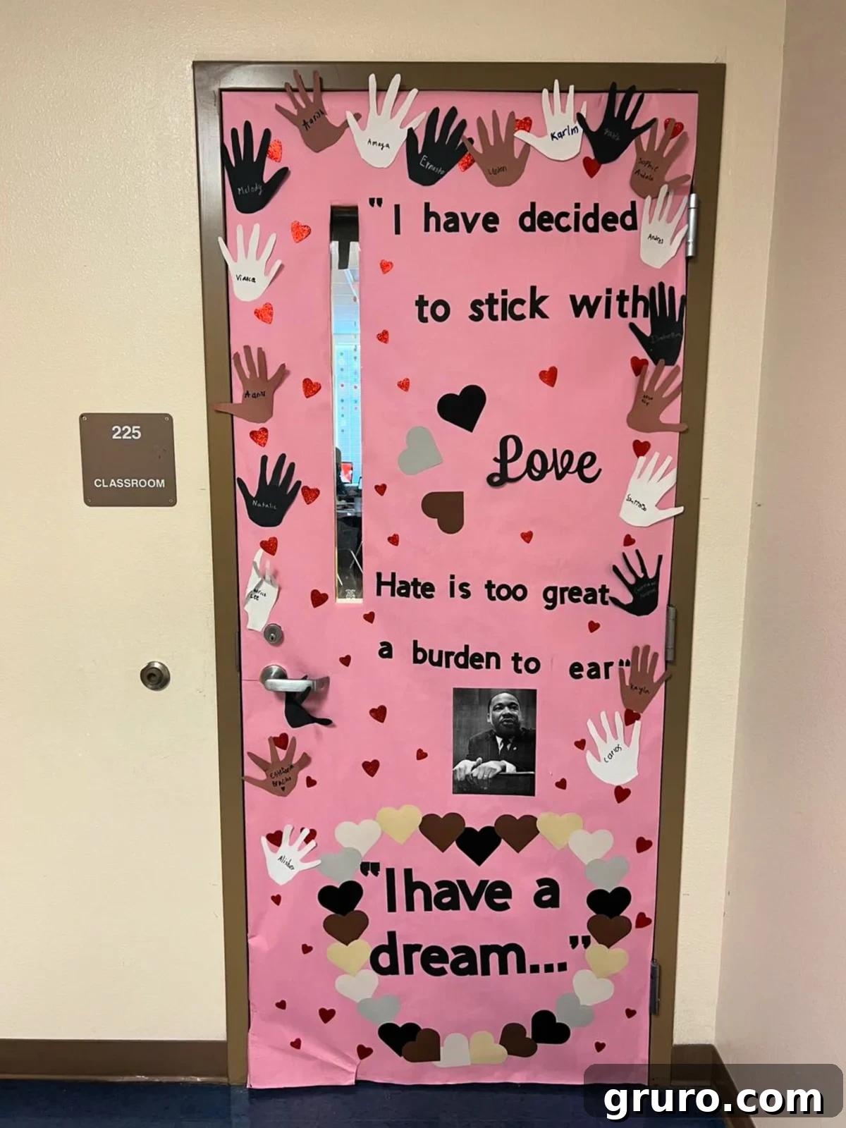 Pink door with hands cut out and names of kids on the door with a photo of MLK and "I have a dream" quote on door.