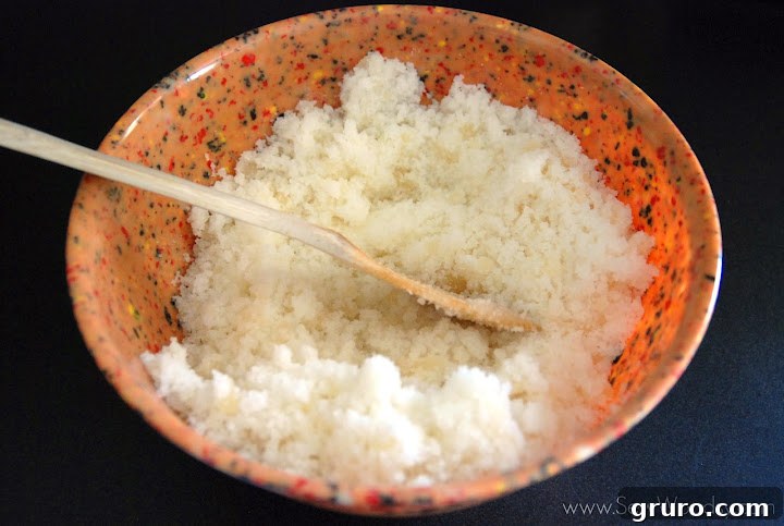 Mixing bowl with sugar, Epsom salt, honey, and lemon oil, beginning to be combined.