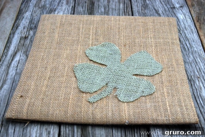 Hot gluing the green burlap clover onto the tan burlap background