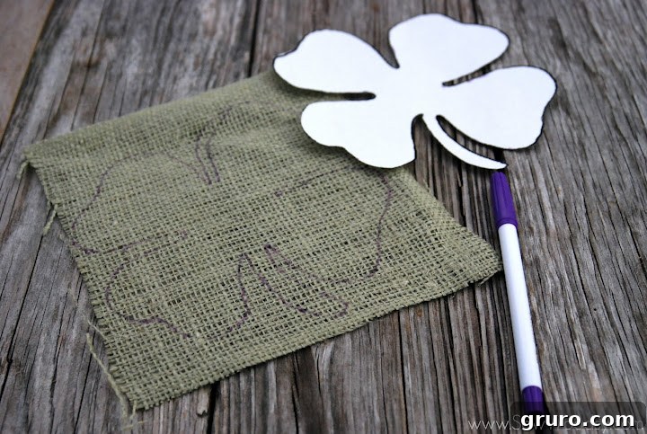 Green burlap with a traced four leaf clover outline